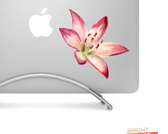 May include: A pink and white watercolor lily flower sticker on a silver laptop.