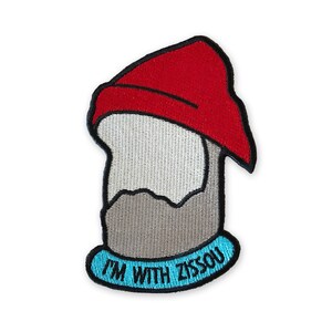 May include: Embroidered patch featuring a cartoon gnome wearing a red hat and a grey beard. The patch has a blue border with the text "I'm with Zissou" in white.