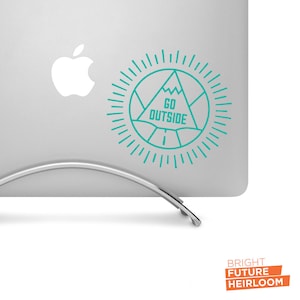 May include: A teal blue sticker with a mountain and sunburst design. The sticker says "GO OUTSIDE" in white text.