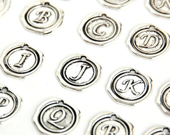 May include: Silver-toned metal alphabet charms with a vintage style. Each charm features a letter of the alphabet in a raised design.