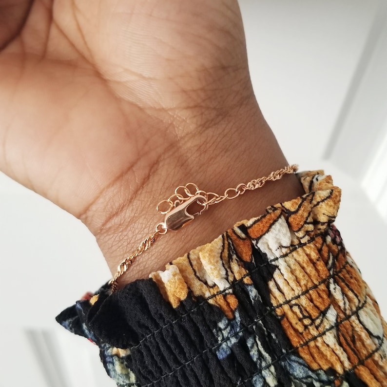 women wearing chain bracelet showing the rose gold lobster clasp and oval extender chain.