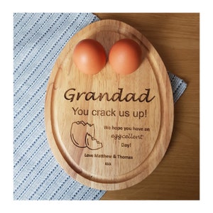 Può includere: Tavolo da portata ovale in legno con due incavi per le uova. Il tavolo è inciso con il testo "Grandad You crack us up! We hope you have an eggcellent Day! Love Matthew & Thomas XXX".