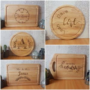 May include: Four personalised wooden chopping boards with engraved text and designs. The boards are made of light brown wood and have a natural finish. The text on the boards includes names, dates, and messages.