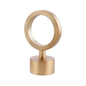 May include: Gold metal curtain finial with a round top and a circular ring. The finial is about 3 inches tall.