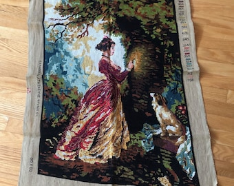 May include: A cross-stitch embroidery kit featuring a woman in a red and gold dress standing in a forest with a dog. The kit includes a printed canvas, DMC floss, and instructions. The title of the piece is "Le Chiffre d'Amour" by J.H. Fragonard, Art 210.