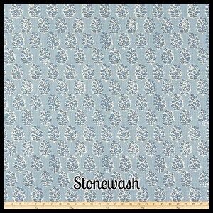 May include: A blue and white patterned fabric with a repeating floral design. The fabric has a stonewash finish and is suitable for various craft projects. The pattern is a light blue background with white floral motifs.