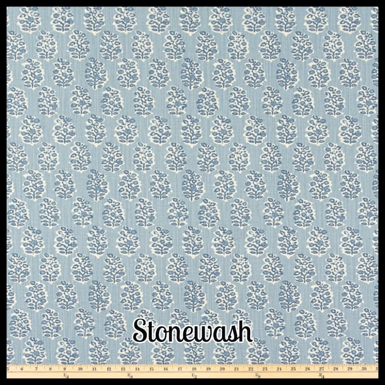 May include: A blue and white patterned fabric with a repeating floral design. The fabric has a stonewash finish and is suitable for various craft projects. The pattern is a light blue background with white floral motifs.