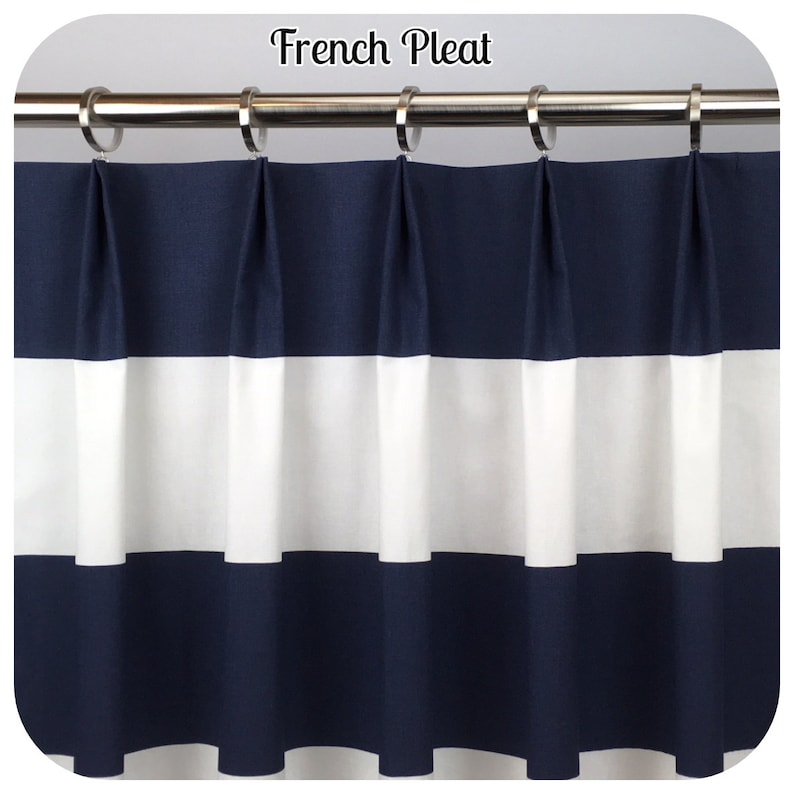 May include: A navy blue and white striped curtain with a French pleat design. The curtain is hanging from a silver rod with silver rings. The text "French Pleat" is at the top of the image.