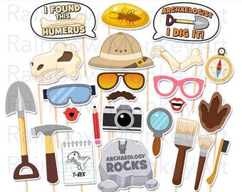 May include: A collection of printable archaeology-themed photo booth props including a pith helmet, dinosaur skull, shovel, hammer, magnifying glass, camera, brushes, compass, amber fossil, and speech bubbles with text I FOUND THIS HUMERUS and ARCHAEOLOGIST I DIG IT.