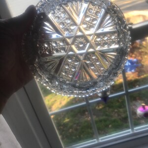 Puede incluir: Un plato de vidrio transparente con un patr&oacute;n geom&eacute;trico decorativo. El plato tiene un borde elevado y un dise&ntilde;o de estrella en el centro.