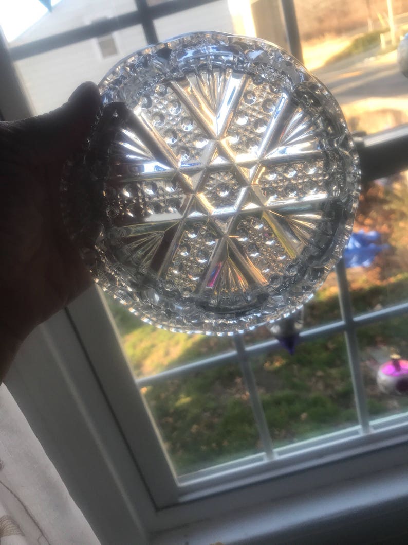 Puede incluir: Un plato de vidrio transparente con un patr&oacute;n geom&eacute;trico decorativo. El plato tiene un borde elevado y un dise&ntilde;o de estrella en el centro.