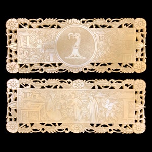 Puede incluir: Dos paneles rectangulares de marfil con intrincados diseños florales tallados. El panel superior presenta un medallón circular con un diseño de pájaro estilizado. El panel inferior representa una escena de personas en un entorno de jardín.