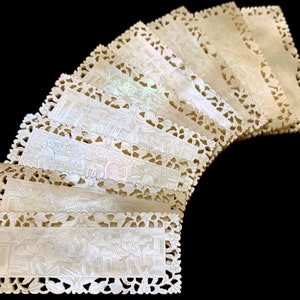 Puede incluir: Un conjunto de diez marcapáginas de nácar tallados con intrincados detalles. Cada marcapáginas presenta un delicado diseño floral y una escena de personas en un jardín.