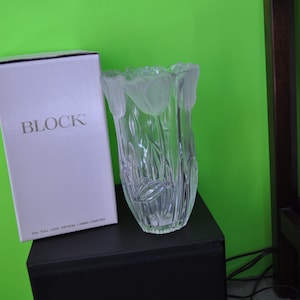 May include: A clear crystal vase with a tulip design, next to a white box with the word "BLOCK" printed on it. The vase has a frosted tulip design around the rim and etched tulip stems. The box reads "24% Full Lead Crystal + Hand Crafted."