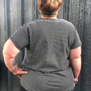 May include: A black and white striped shirt with short sleeves. The shirt is loose fitting and has a relaxed fit.