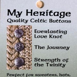 May include: Two silver Celtic knot buttons with intricate designs. The buttons are made from lead-free polished pewter. The text on the card reads "My Heritage Quality Celtic Buttons Everlasting Love Knot The Journey Strength of the Trinity Perfect for sweaters, hats, bags, gloves, knitwear Made from lead-free polished pewter."