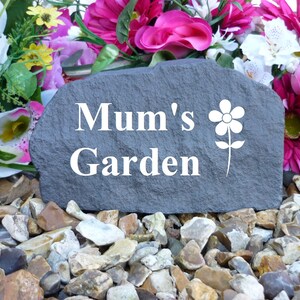 May include: A gray stone garden marker with the text "Mum's Garden" and a white flower design.