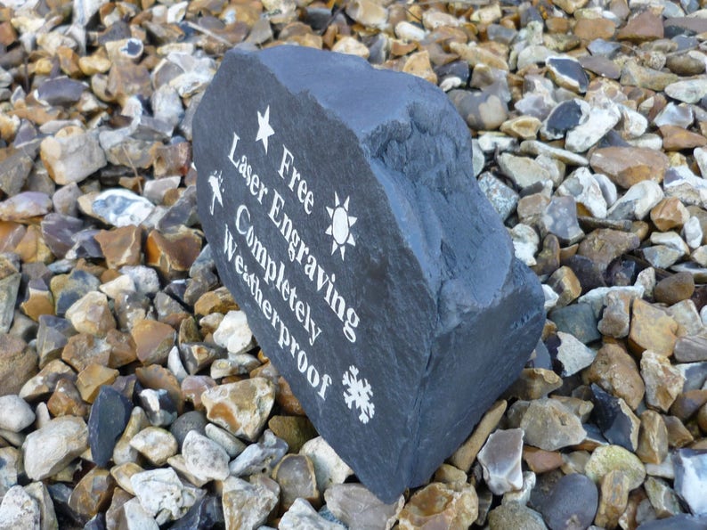 May include: A dark gray stone with white text that reads "Free Engraving Laser Etched Completely Weatherproof" with a star, sun, and snowflake symbols.