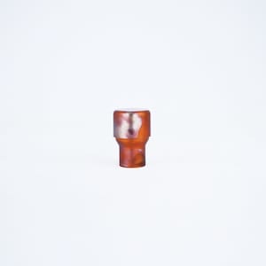 May include: A brown and silver bottle stopper with a marbled design.