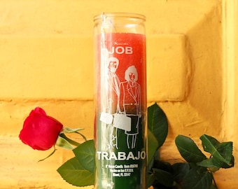 Puede incluir: Una vela cilíndrica alta de cristal con cera roja en la parte superior y verde en la inferior. La etiqueta presenta dibujos lineales blancos de dos personas con ropa de negocios y el texto JOB y TRABAJO, con 15 cm Vision Candle, Item #35705.