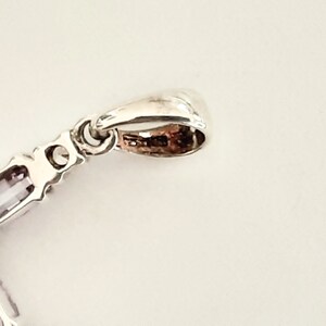 Pu&ograve; includere: Ciondolo in argento con una pietra preziosa viola e una baionetta in argento. La baionetta &egrave; un anello che serve per attaccare il ciondolo a una catena.