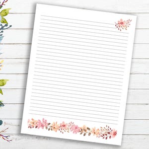 May include: White lined paper with a floral border at the bottom. The border is made up of pink, orange, and brown flowers. There is a small floral design in the top right corner.
