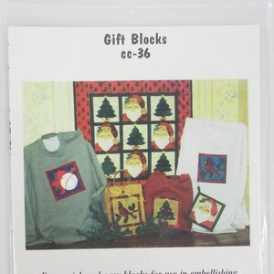 May include: A printed pattern sheet for four quick and easy quilt blocks. The blocks feature a Santa Claus, a Christmas tree, a cardinal, and a snowman. The pattern sheet is titled "Gift Blocks cc-36" and includes contact information for Custom Creations.