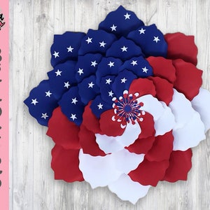 May include: A red, white, and blue paper flower with a star-spangled center. The flower is made of multiple layers of paper, creating a 3D effect. The flower is perfect for patriotic decorations.