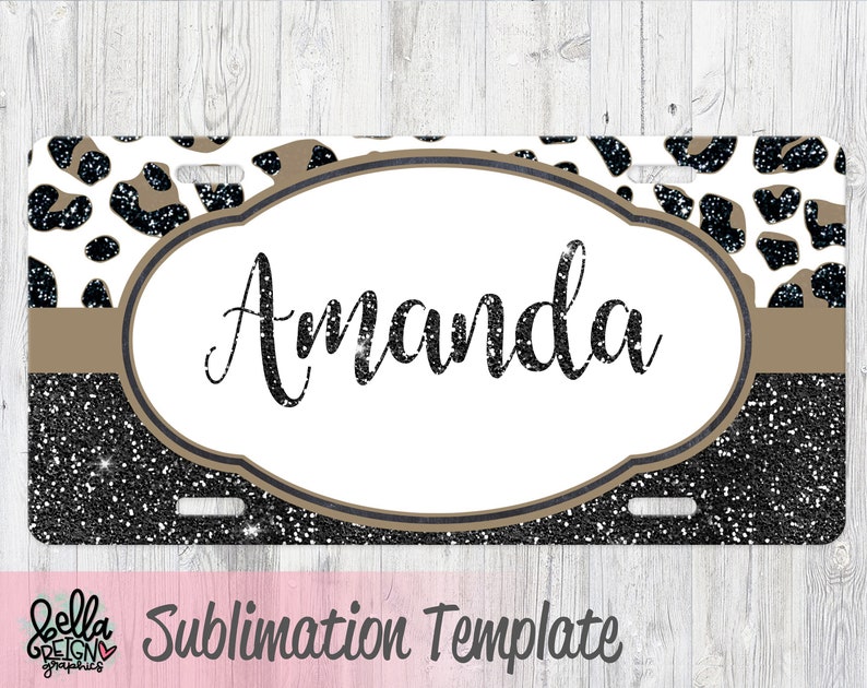 May include: Sublimation template for a license plate featuring a black and white leopard print with brown glitter accents. The template has a white oval with a brown border and the text "Amanda" in black glitter.