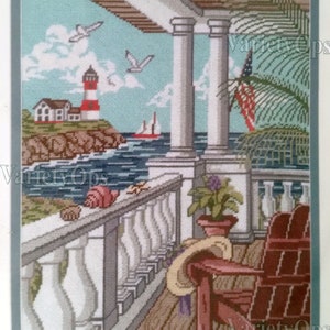 May include: Needlepoint scene of a coastal view with a lighthouse, ocean, and a porch with a wooden chair. The scene includes an American flag, seagulls, and seashells. The color palette is primarily blues, greens, and browns.