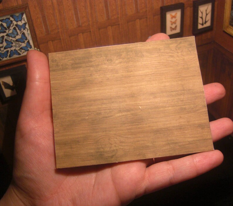 Pu&ograve; includere: Primo piano di un foglio di carta con texture effetto legno di colore marrone chiaro. La carta ha una superficie leggermente ruvida ed &egrave; tenuta in una mano.