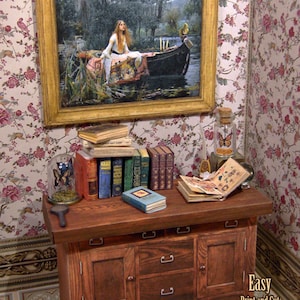 Pu&ograve; includere: Un cassettone in legno in miniatura con tre cassetti e due ante. Il cassettone &egrave; decorato con maniglie dei cassetti argentate. Il cassettone &egrave; posto su un pavimento piastrellato con motivi. Ci sono libri, una lente d'ingrandimento e un barattolo di vetro con una farfalla all'interno sopra il cassettone. Un dipinto incorniciato di una donna in una barca &egrave; appeso al muro dietro il cassettone.