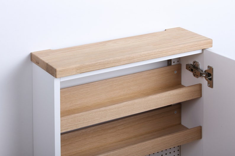 May include: White shoe cabinet with a wooden top and shelves. The cabinet door is open, revealing the interior shelves.