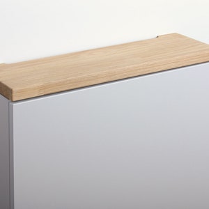 May include: A light grey cabinet with a wooden oak top. The cabinet is made of wood and has a modern design.