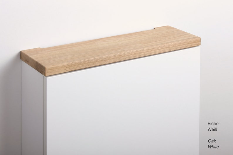 May include: A white cabinet with a light wood top. The cabinet is labelled "Eiche Wei&szlig;" and "Oak White".