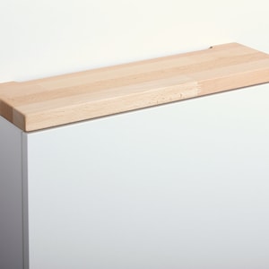 May include: White cabinet with a beech wood top. The text "Buche Wei&szlig;" and "Beech White" is visible below the cabinet.