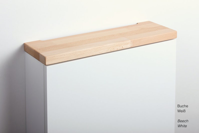 May include: White cabinet with a beech wood top. The text "Buche Wei&szlig;" and "Beech White" is visible below the cabinet.
