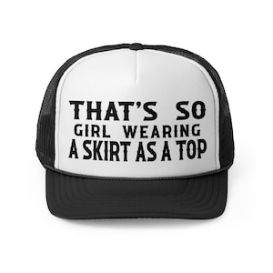 Puede incluir: Una gorra de camionero negra y blanca con un panel frontal blanco y una malla negra en la parte posterior. El panel frontal tiene el texto "THAT'S SO GIRL WEARING A SKIRT AS A TOP" en negro.
