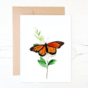 Farfalla monarca appoggiata su una carta da nota floreale Gardenia 100% carta riciclata.