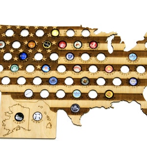 Puede incluir: Mapa de madera de los Estados Unidos de América con un diseño de la bandera estadounidense. El mapa tiene 50 círculos para tapas de botellas, que representan cada estado. El mapa está hecho de madera marrón claro y tiene un aspecto desgastado.