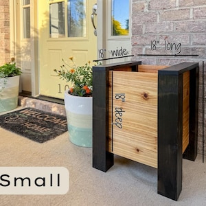 May include: A small wooden planter box with black trim and natural wood panels. The planter is 18 inches wide, 18 inches deep, 18 inches long, and 24 inches tall. The word "Small" is at the bottom.