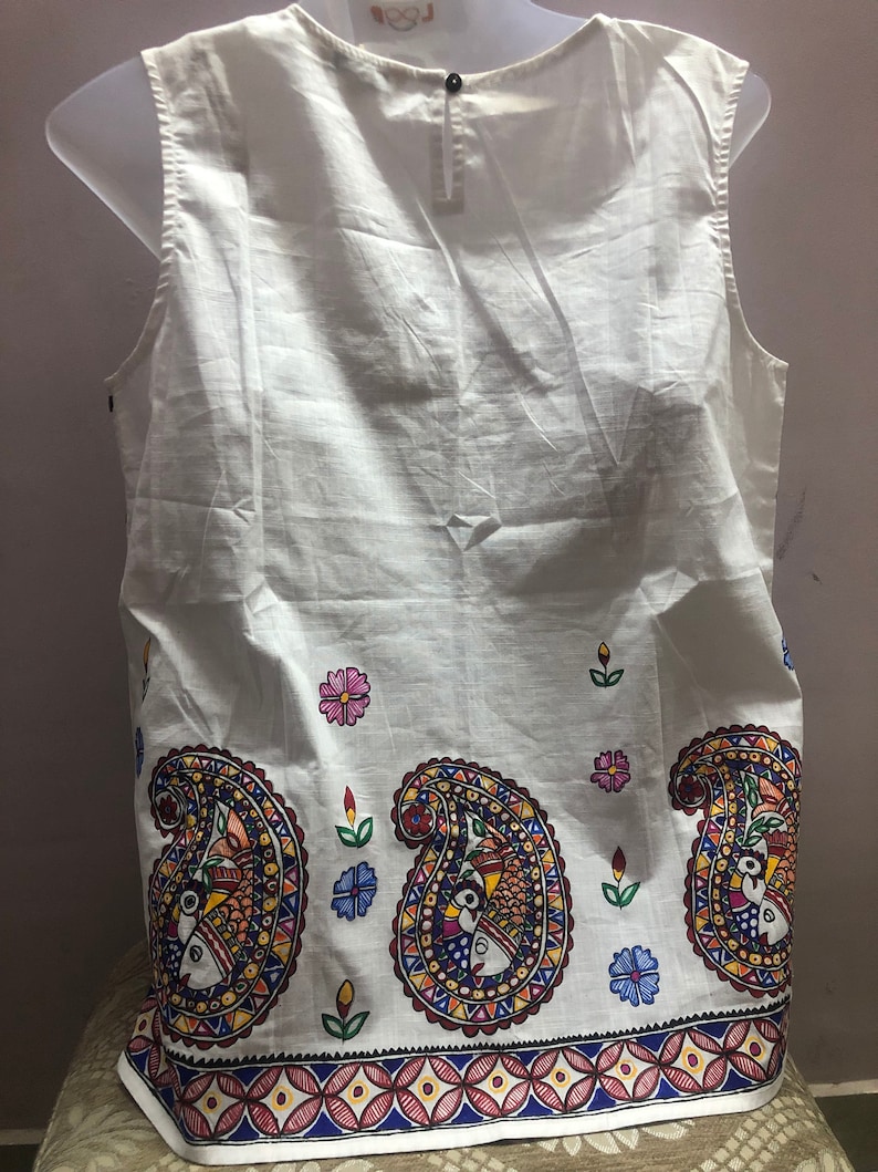 May include: White sleeveless top with a paisley print in shades of blue, red, yellow, and green. The print features stylized birds and flowers.