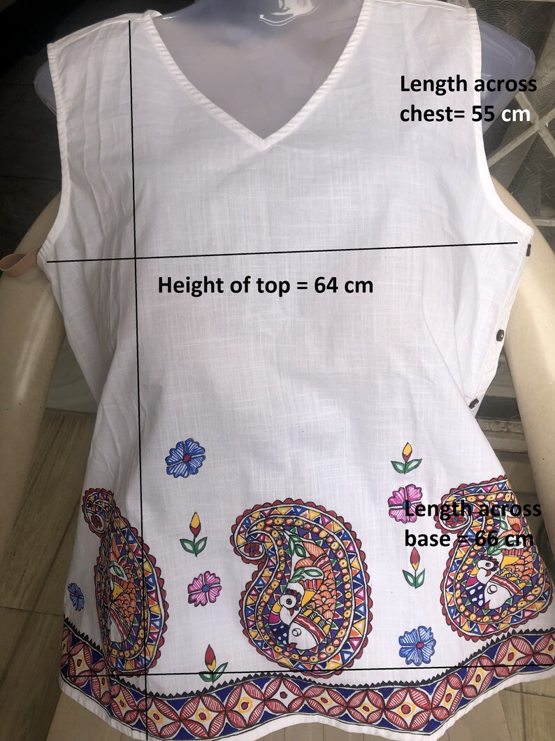 May include: White sleeveless top with a V-neck and a paisley print. The top measures 64 cm in height and 55 cm across the chest. The base of the top measures 66 cm across.