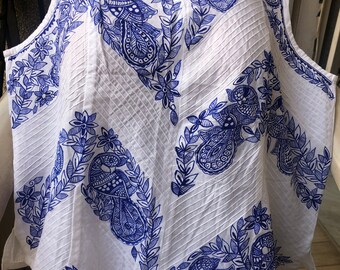 May include: White sleeveless top with a blue paisley pattern. The pattern features intricate details and a floral design.