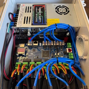 May include: A close-up of a circuit board with wires and connectors. The board is labeled "F16V5 v1.03". A power supply unit is visible in the background, labeled "Visionary Light Shows".