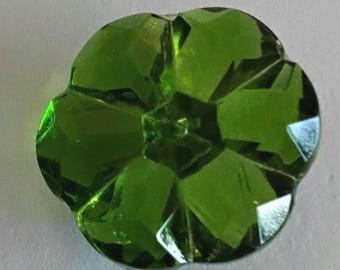 May include: A vibrant lime green, flower-shaped button crafted from faceted glass. The button features a central point with five distinct, rounded petals radiating outward, each with sharp, geometric facets that reflect light across the surface.