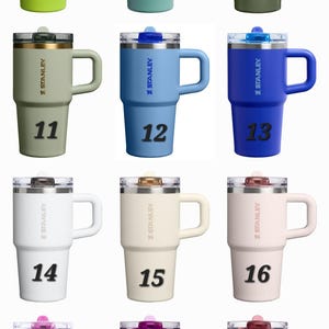 Op de afbeelding: Een verzameling ge&iuml;soleerde Stanley-bekers in diverse kleuren, waaronder groen, blauw en roze. Elke beker heeft een handvat en een doorzichtig deksel. De nummers 8 tot en met 19 staan op de voorkant.