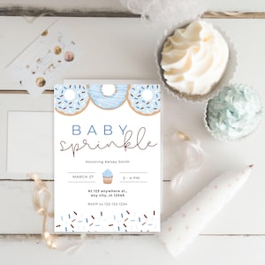 Może przedstawiać: Niebieskie i białe zaproszenie na baby shower z motywem pączk&oacute;w. Zaproszenie zawiera napis "Baby Sprinkle" oraz datę, godzinę i miejsce wydarzenia. Zawiera r&oacute;wnież informacje dotyczące RSVP.