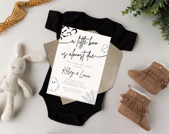 Könnte beinhalten: Eine Babyparty-Einladung mit dem Text "A little boo is almost due" wird auf einem schwarzen Body angezeigt. Die Einladung enthält die Namen Kelsey & Lance, eine Geisterillustration und braune Babystiefel.