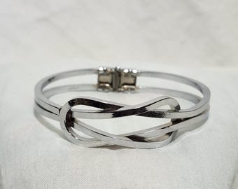 Pulsera rígida articulada con nudo de amor - Tono plateado